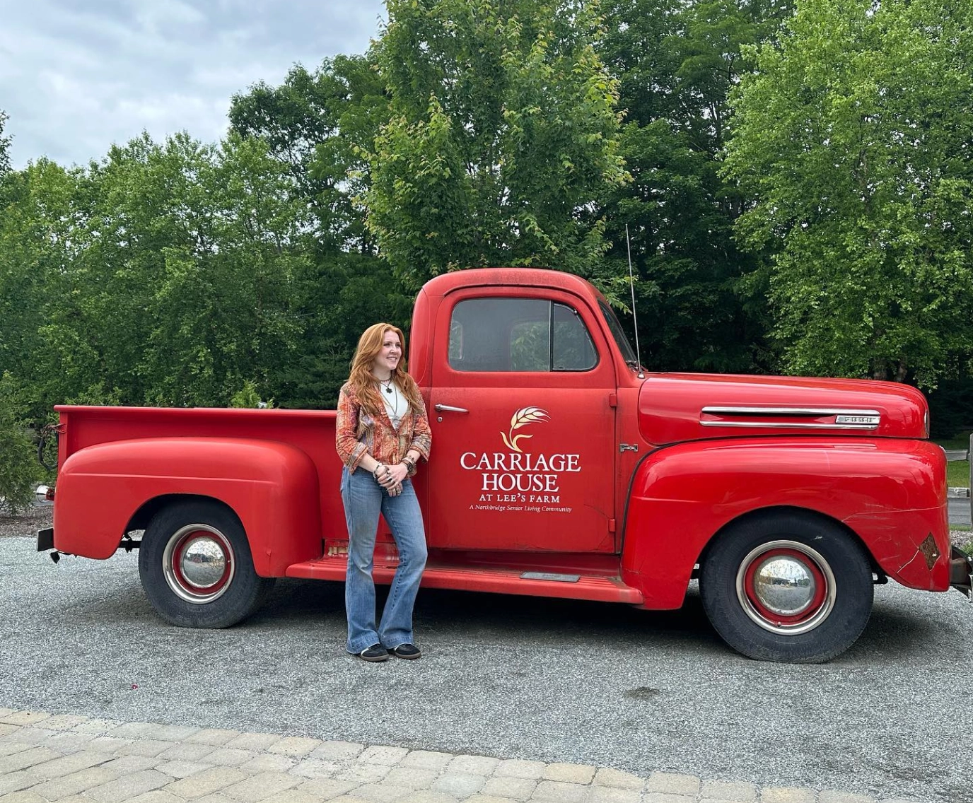 Catherine McGonagle, STEMS Co-Founder & President, standing in front of a red truck at Lee's Farm